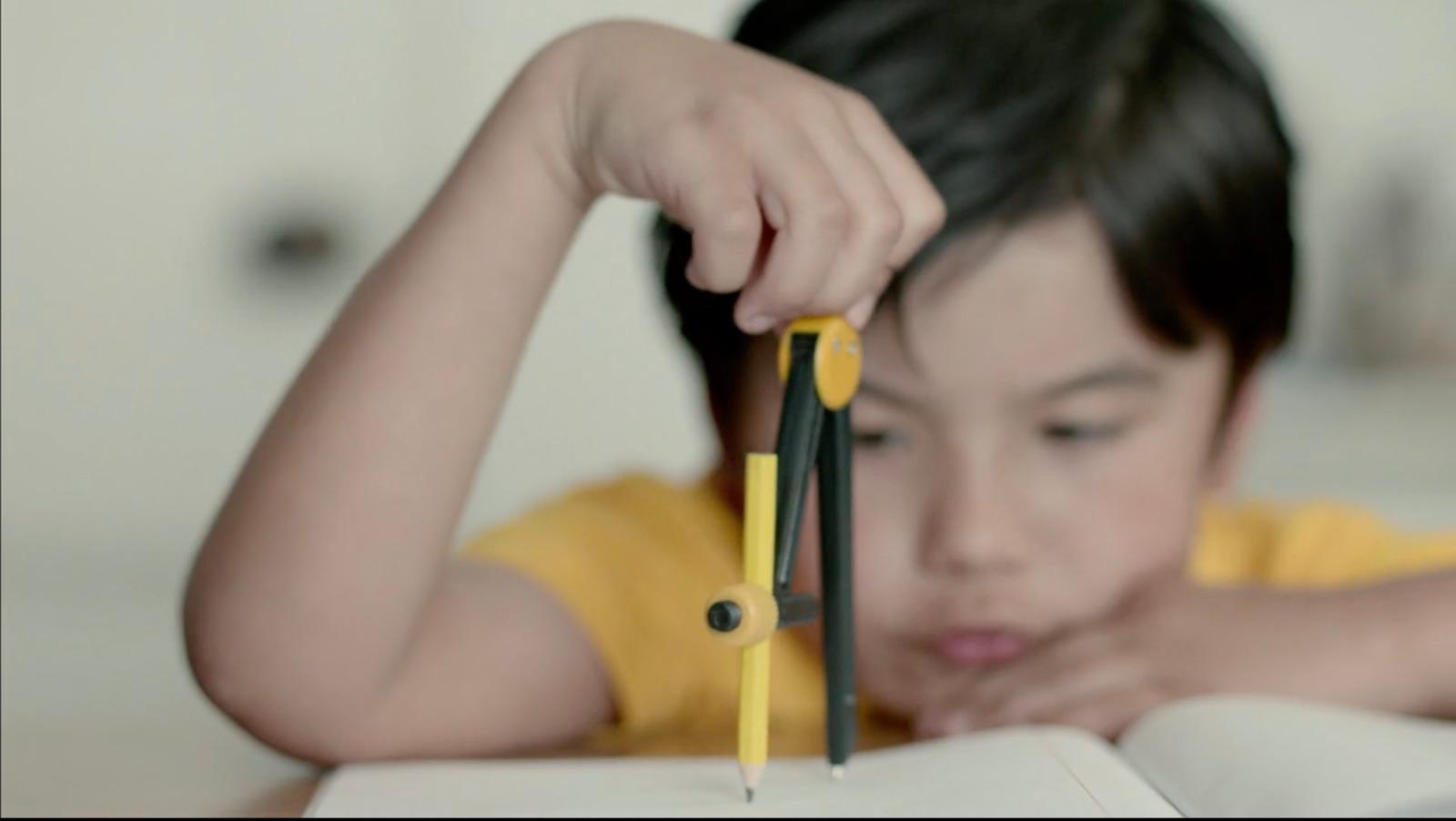a little girl holding a pair of scissors over a book