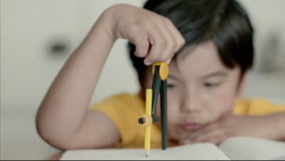a little girl holding a pair of scissors over a book