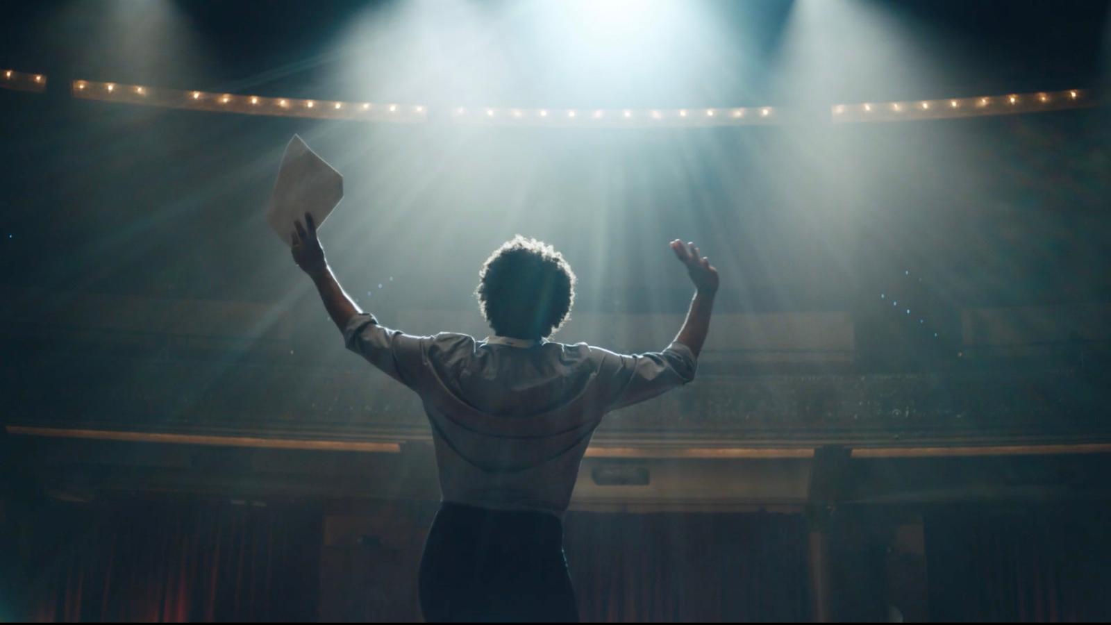 a man standing in front of a stage with his hands up