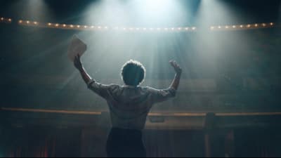a man standing in front of a stage with his hands up