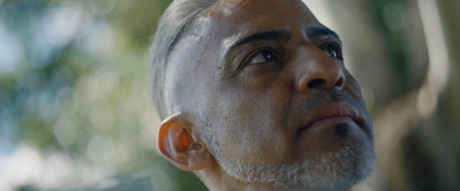 a close up of a person with a tree in the background