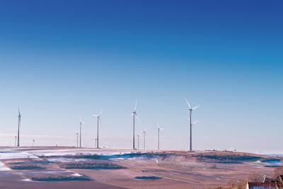 a row of wind turbines on top of a hill