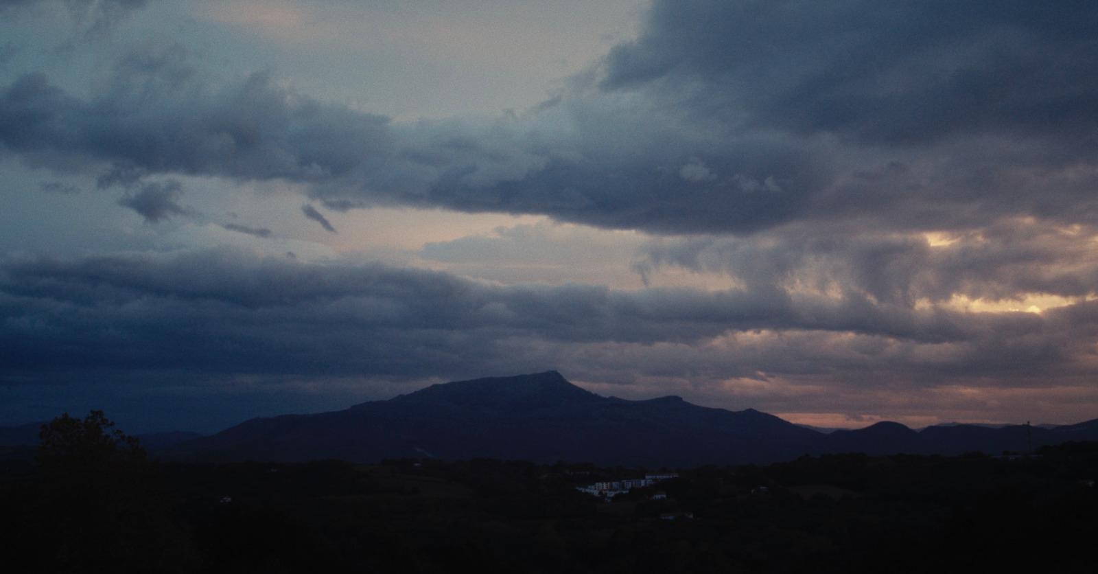 a view of a mountain range with clouds in the sky