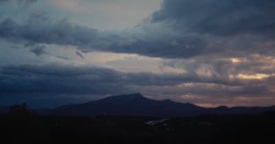 a view of a mountain range with clouds in the sky