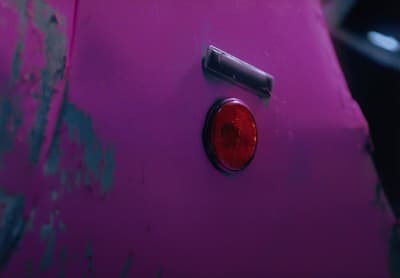 a close up of a pink car with a red light