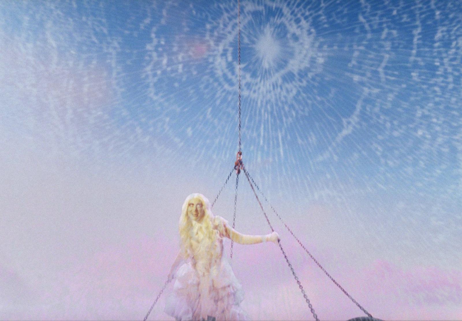 a woman in a white dress holding onto a chain