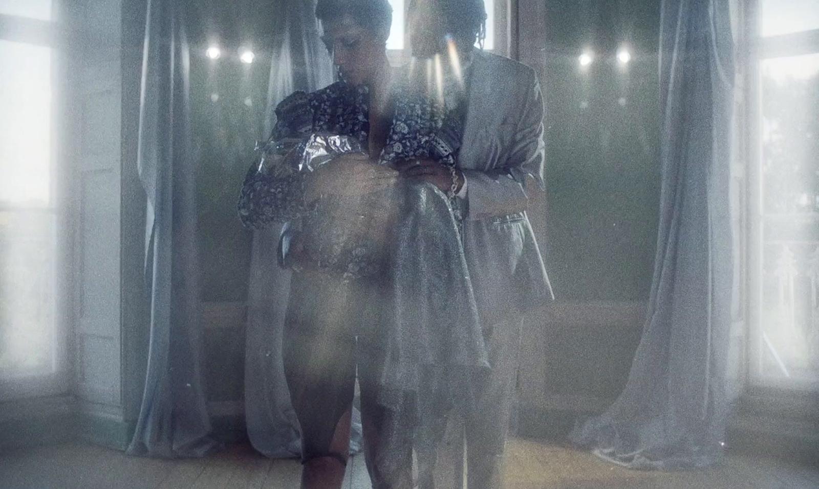 a woman standing in front of a window holding a cell phone