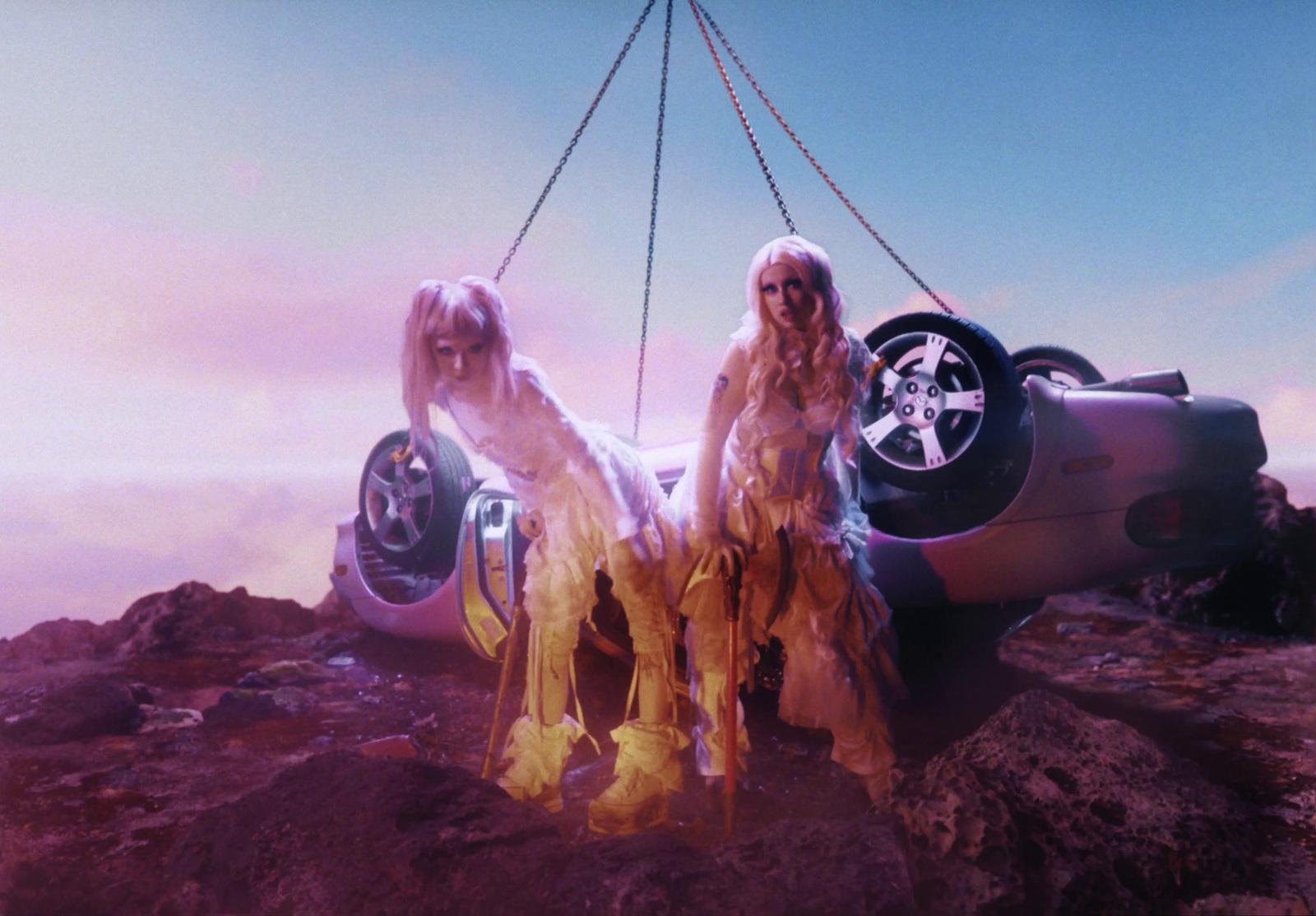 a couple of women standing next to a car