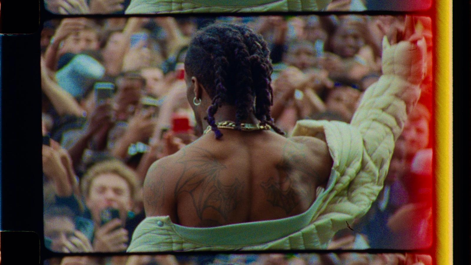 a person with dreadlocks standing in front of a crowd