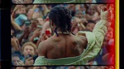 a person with dreadlocks standing in front of a crowd