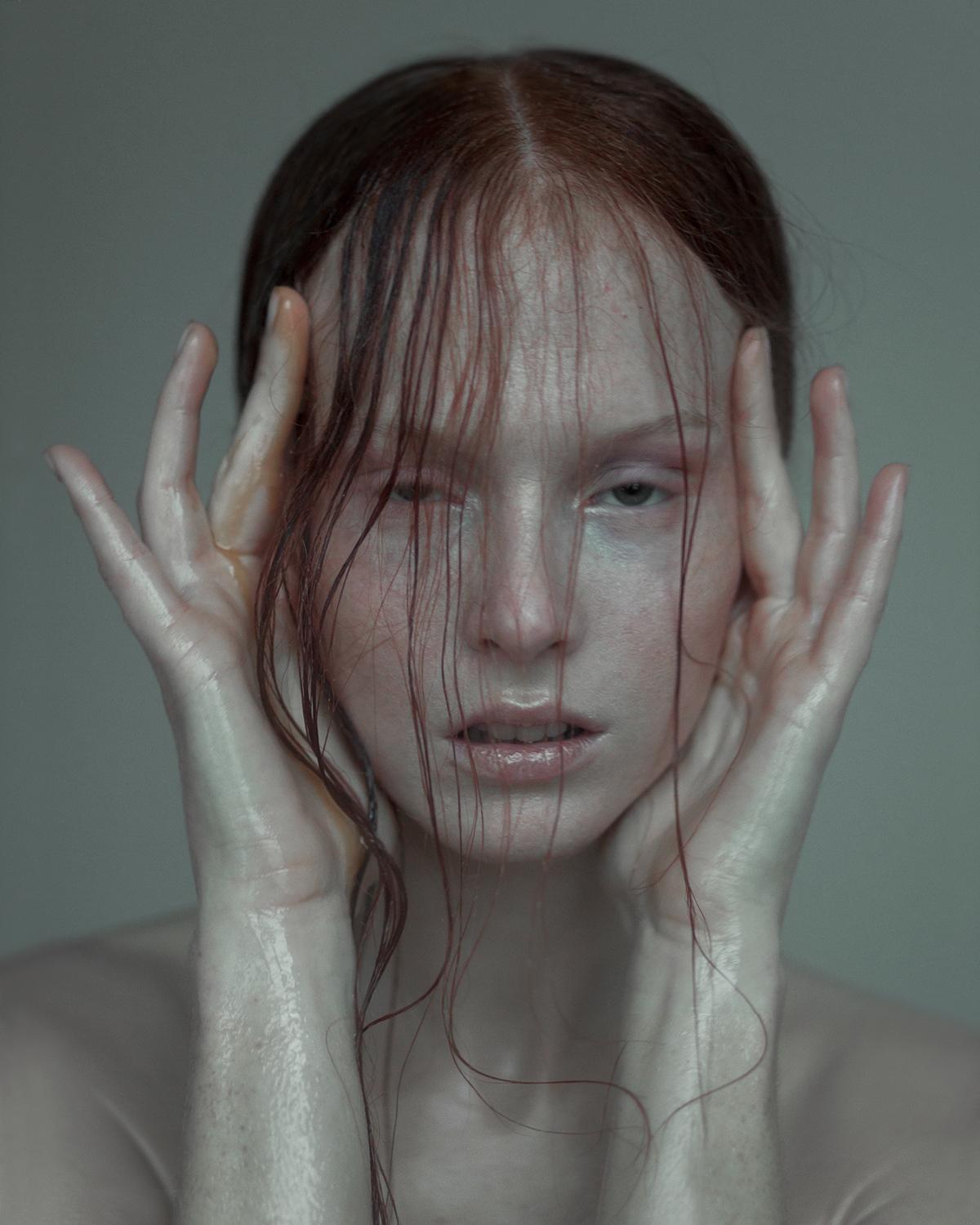 a woman with red hair holding her hands to her face