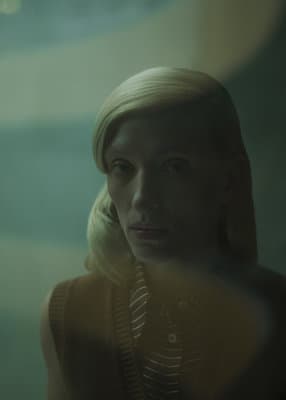 a woman with blonde hair looking at the camera