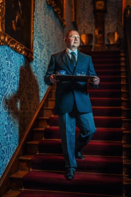 a man in a suit and tie is walking down a set of stairs