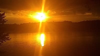 the sun is setting over a body of water