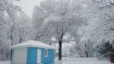 a small blue and white building in the snow