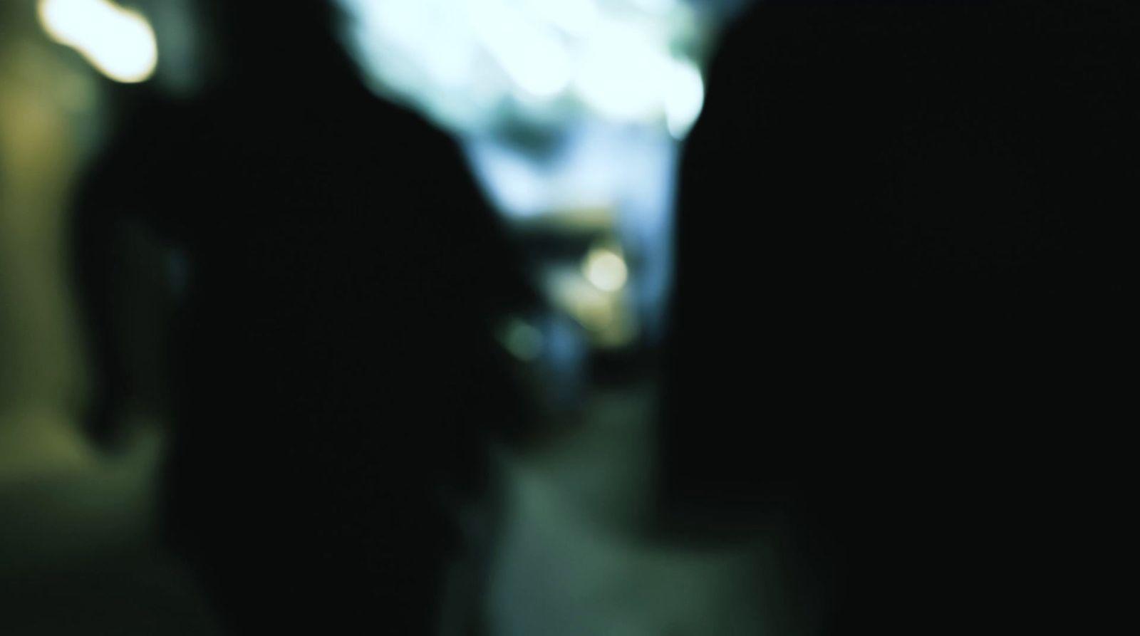 a blurry photo of two people walking down a street
