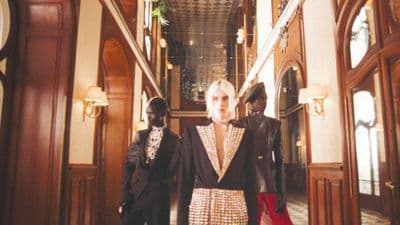 a woman standing in a hallway between two men