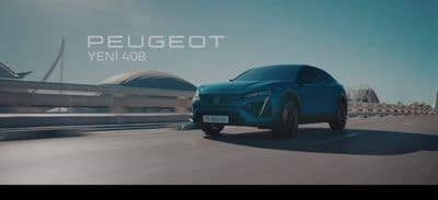 a blue car driving down a road next to a bridge