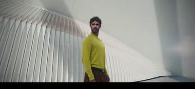 a man standing in front of a white wall