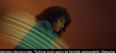 a woman with curly hair standing in front of a wall