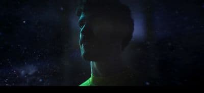 a man standing in the dark with his eyes closed