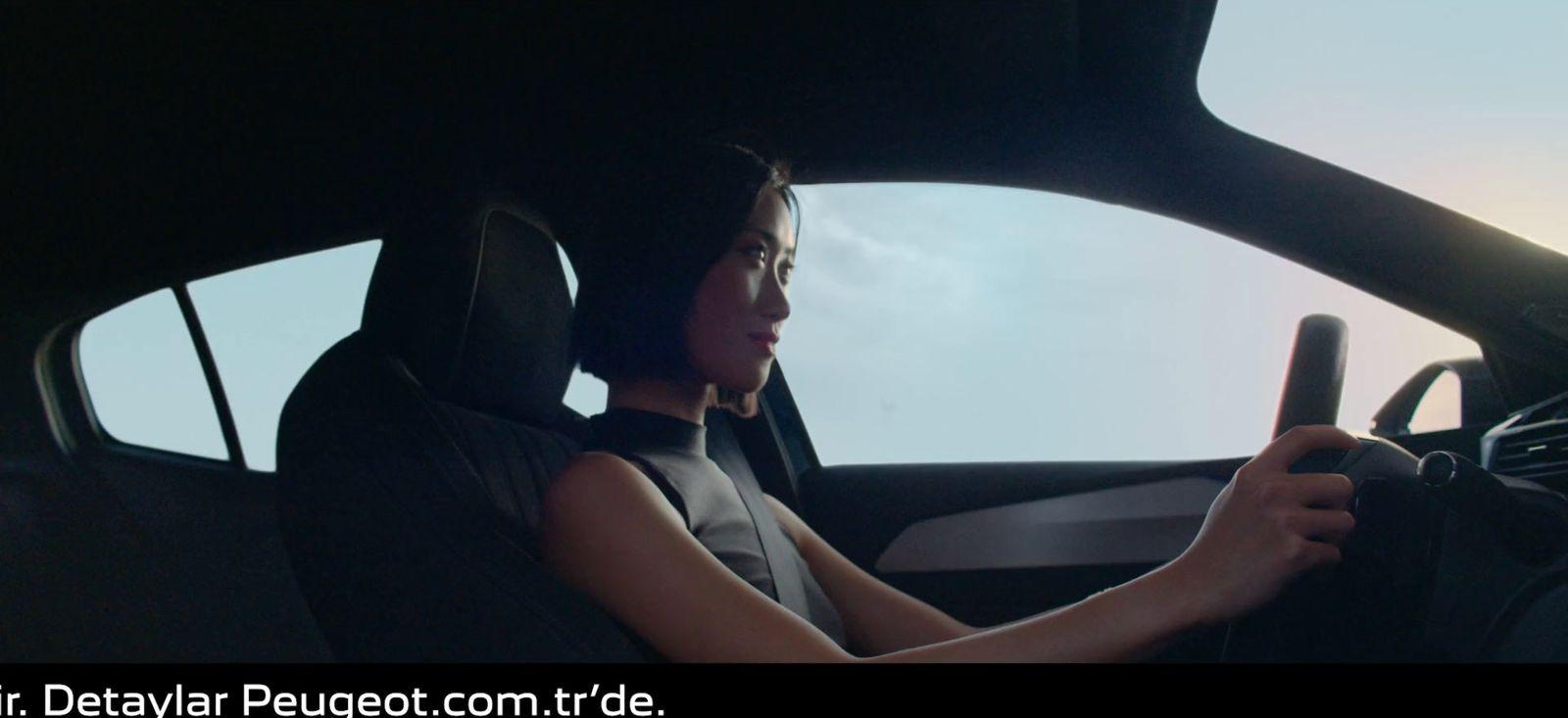 a woman sitting in a car holding a steering wheel