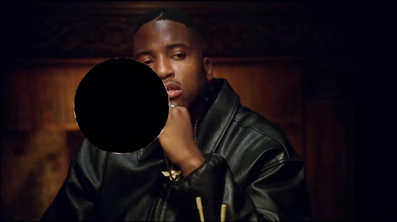 a man in a black leather jacket holding his hand to his face