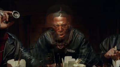 a man in a leather jacket sitting at a table