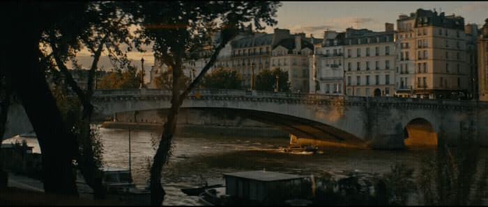 a bridge over a body of water with buildings in the background