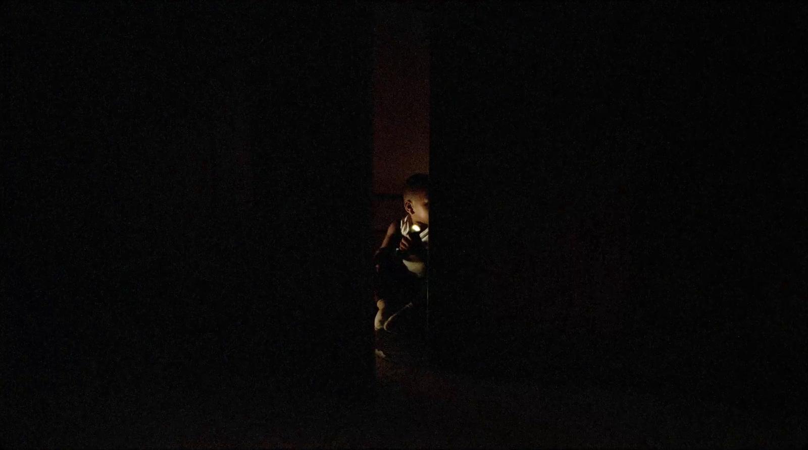 a person standing in the dark with a cell phone