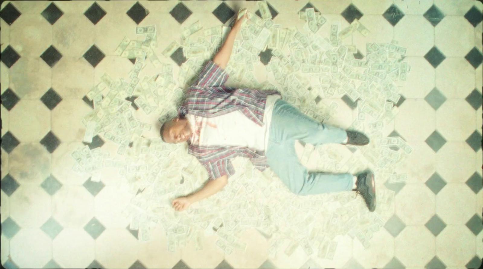 a man laying on a tiled floor with his arms in the air