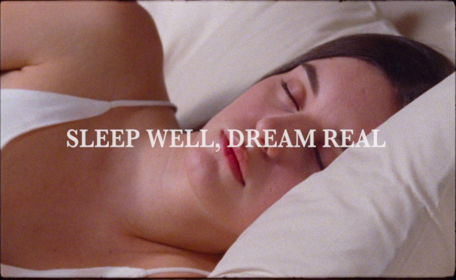 a woman laying in bed with her eyes closed