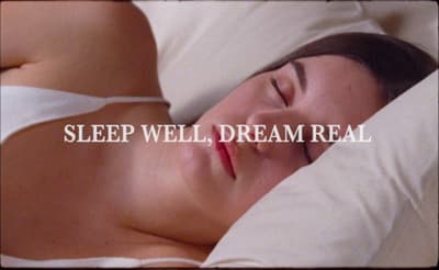 a woman laying in bed with her eyes closed