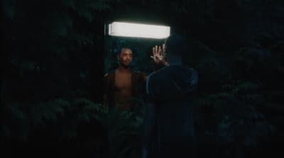 a man standing in front of a mirror in the dark