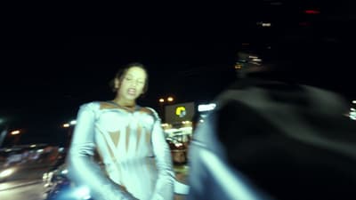 a woman in a white dress walking down the street