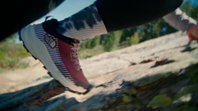 a close up of a person's shoes on a rock