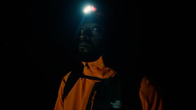 a man standing in the dark with a light on his head