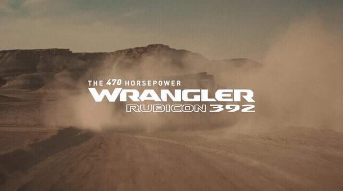 a truck driving down a dirt road in the desert