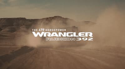 a truck driving down a dirt road in the desert