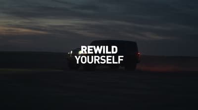 a truck driving down a road with the words re wild yourself written on it