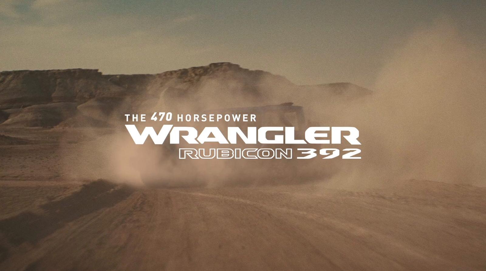 a truck driving down a dirt road next to a mountain