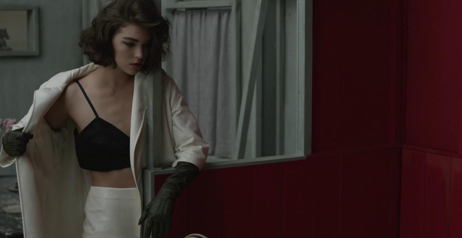 a woman in a black bra top and white skirt