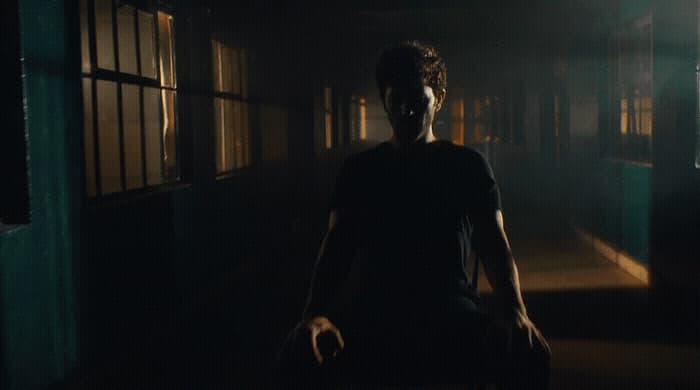 a man in a dark room with a creepy look on his face