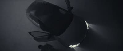 a car parked in a dark room with a light shining on it
