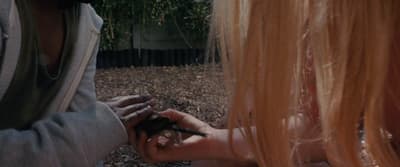 a woman holding a cell phone to another woman's hand