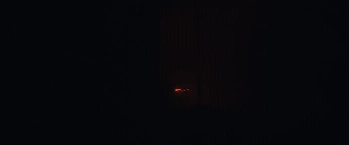 a red light is shining in the dark