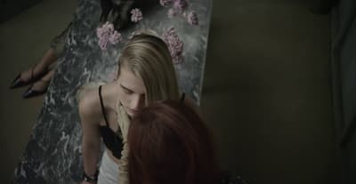 a woman standing next to another woman in a room