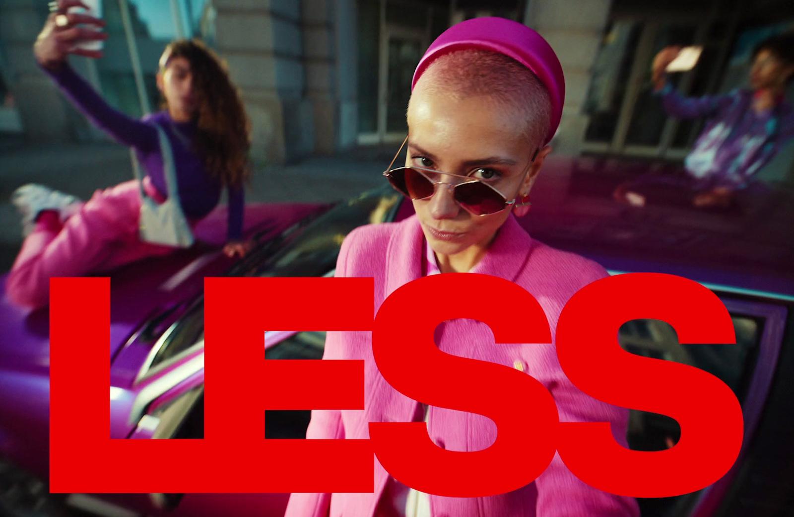 a woman in a pink outfit standing next to a car
