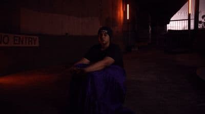 a man sitting on a bench in the dark