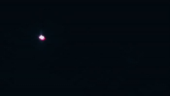 a red light is shining in the dark sky